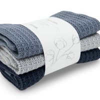 Stack of folded organic cotton facecloths with ecovask brand label on a white background