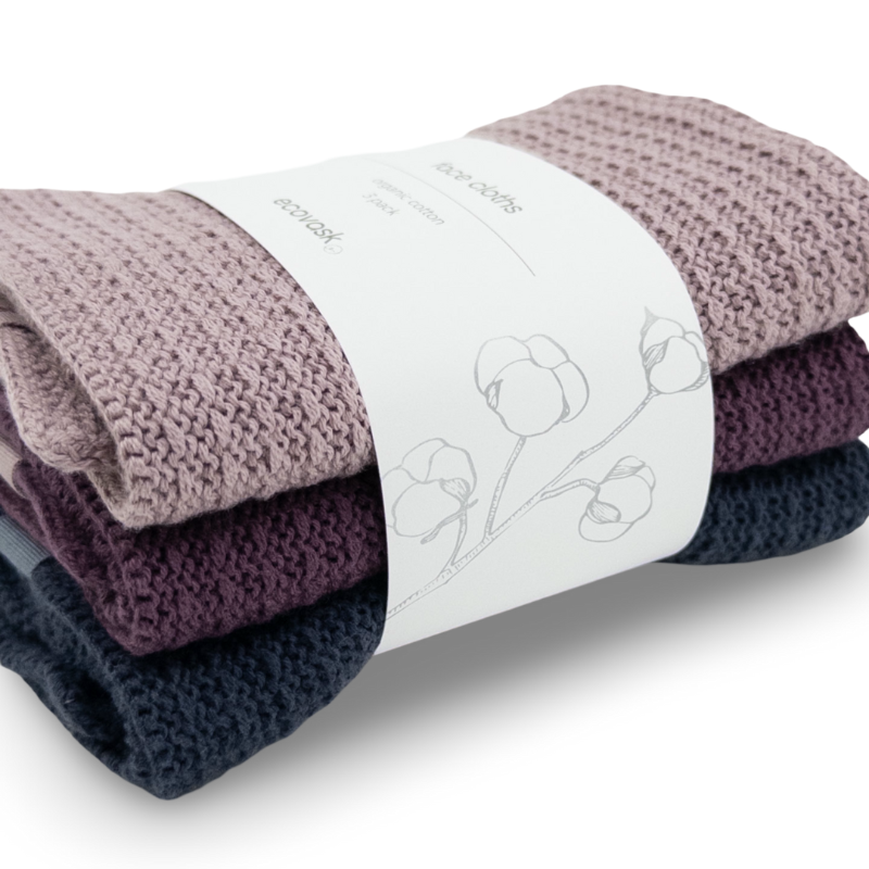 Stack of folded knitted organic cotton face cloths with a ecovask brand label on a white background