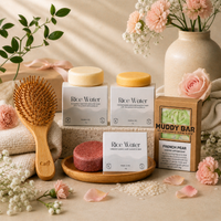 bundle of sustainable haircare products, including shampoo and conditioner bars, a bamboo hair brush and a body soap