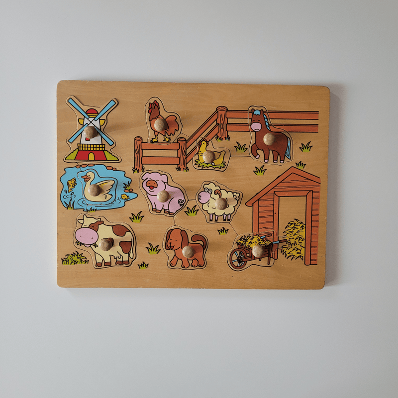 Wooden puzzle with farm animal figures on a plain background