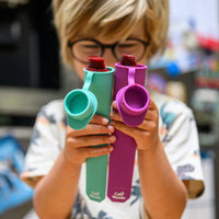 Child holding colourful silicone ice block moulds with fruity popsicle.