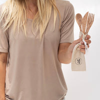 Person holding coconut cutlery in their hand. Spoon, Knife and Fork with travel bag