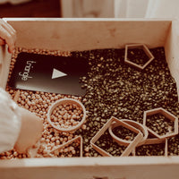Shape dough cutters on a box of lentils with a childs hand and 'triangle' shape card